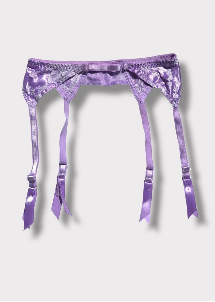 Purple satin garter belt with a star design on a light gray background
