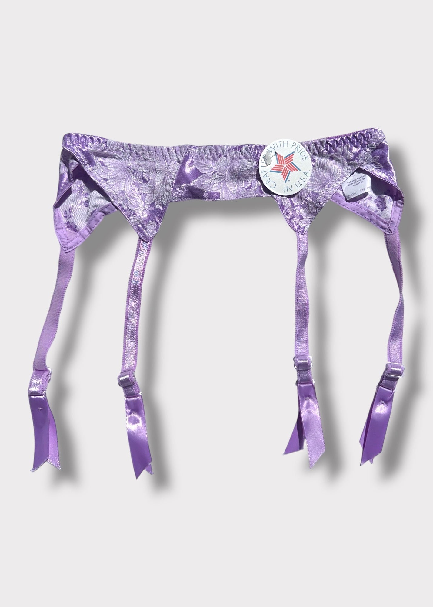 Purple satin garter belt with a brand logo on a white background
