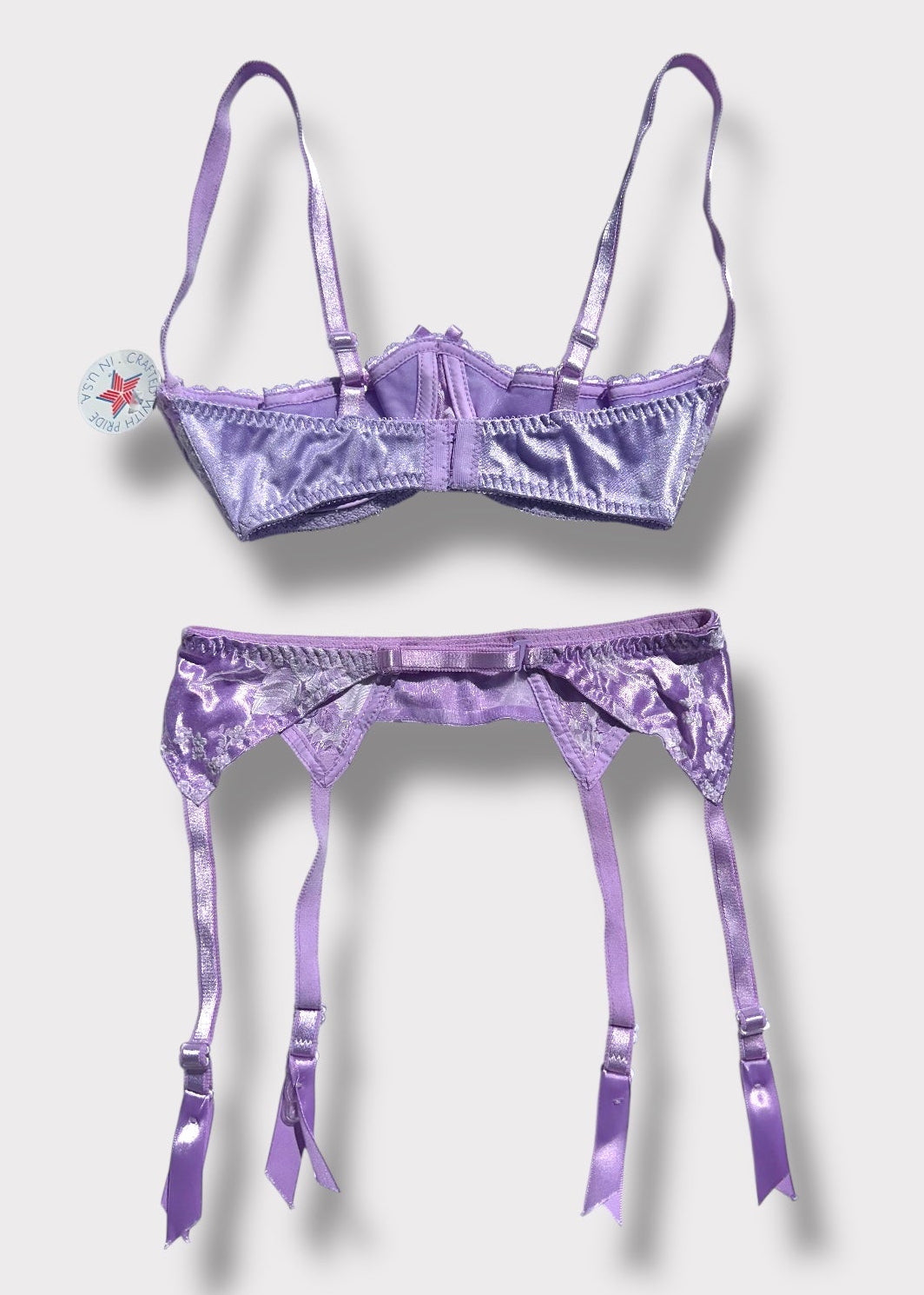 Purple lingerie set with matching garter on a white background
