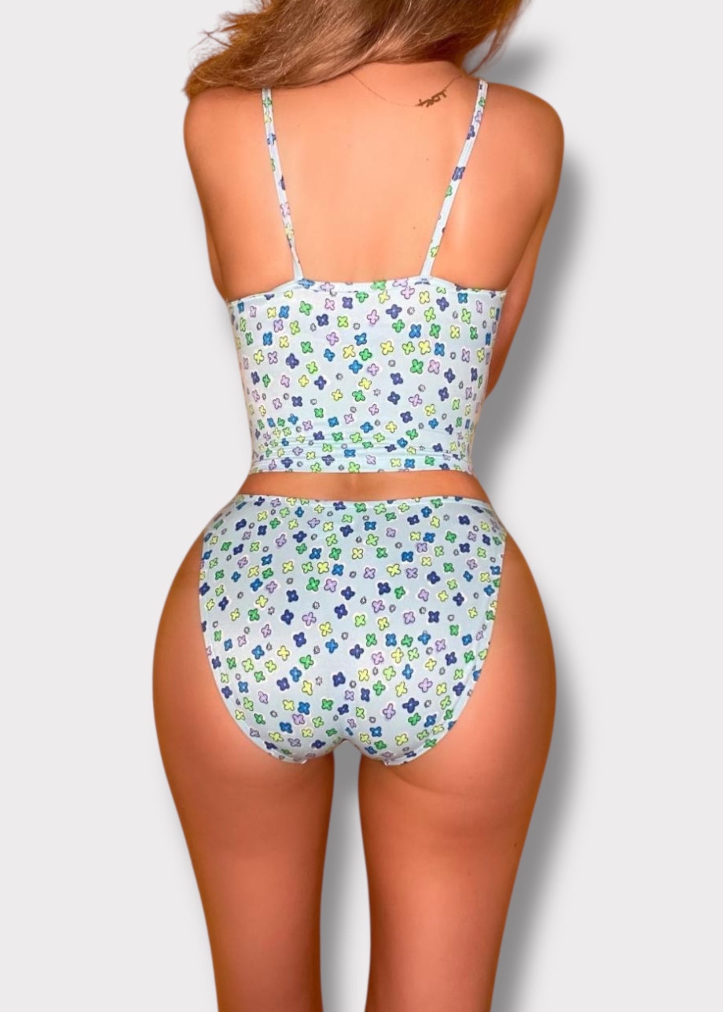 Woman wearing a patterned two-piece swimsuit on a plain background