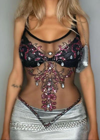 Woman wearing a black and silver embellished outfit against a gray background