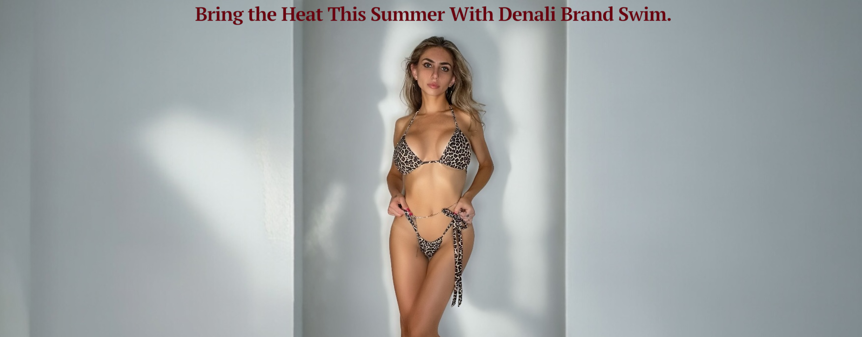 Woman in a bikini standing against a plain background with promotional text for Denali Brand Swim.
