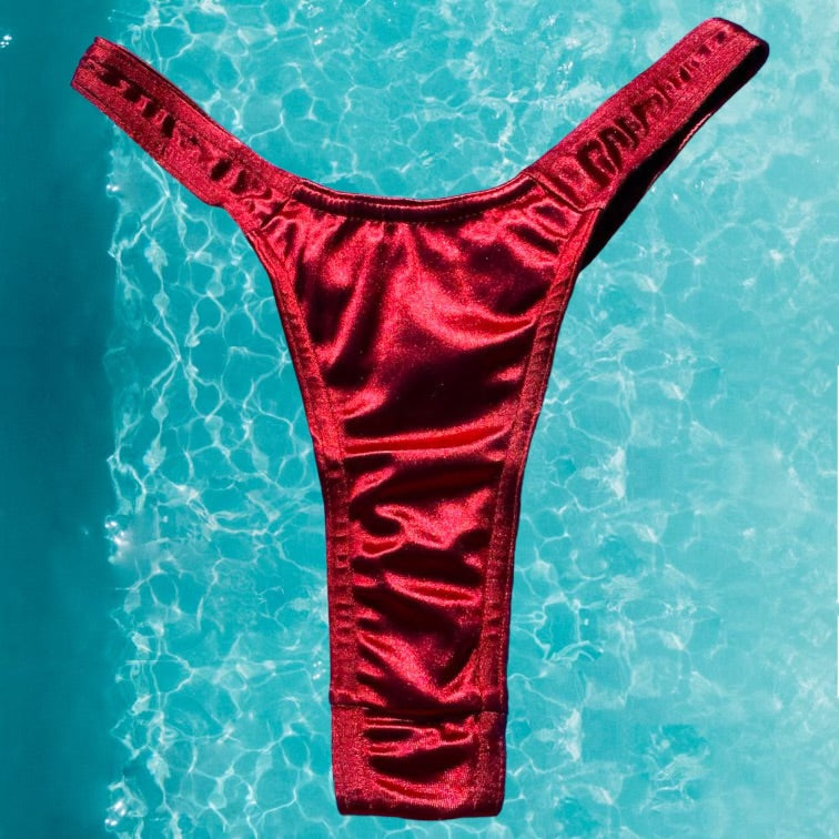 
                      
                        Satin Shimmer Ultra Flattering Thong Bikini Bottom | Cranberry
                      
                    