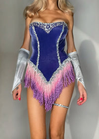 A model wearing a strapless velvet corset-style costume in deep blue with silver rhinestone trim, a pink-to-purple fringe hem, and matching silver arm sleeves, photographed against a plain light gray wall.
