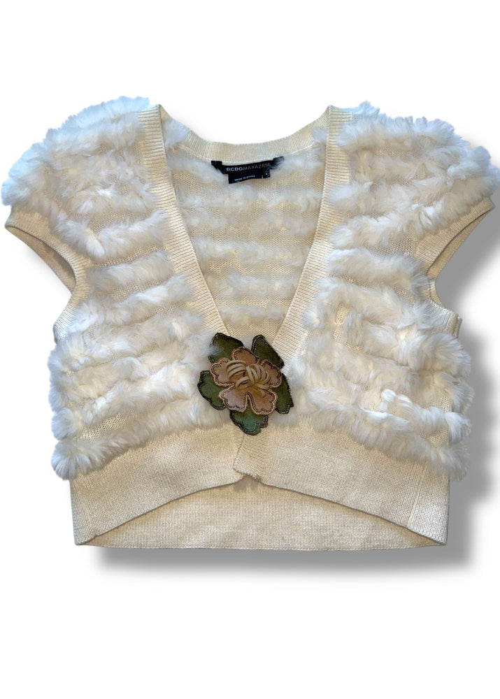 Beige cardigan with white fluffy trim and floral brooch on a white background