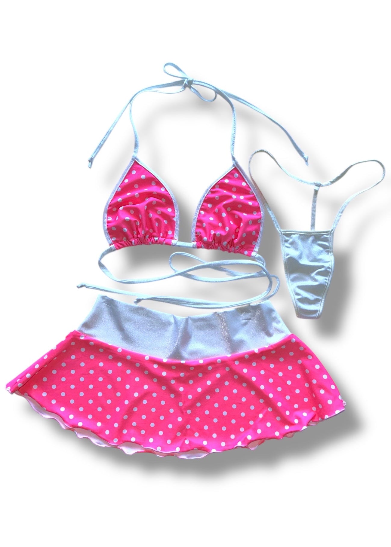 Pink and white polka dot bikini set on a white background