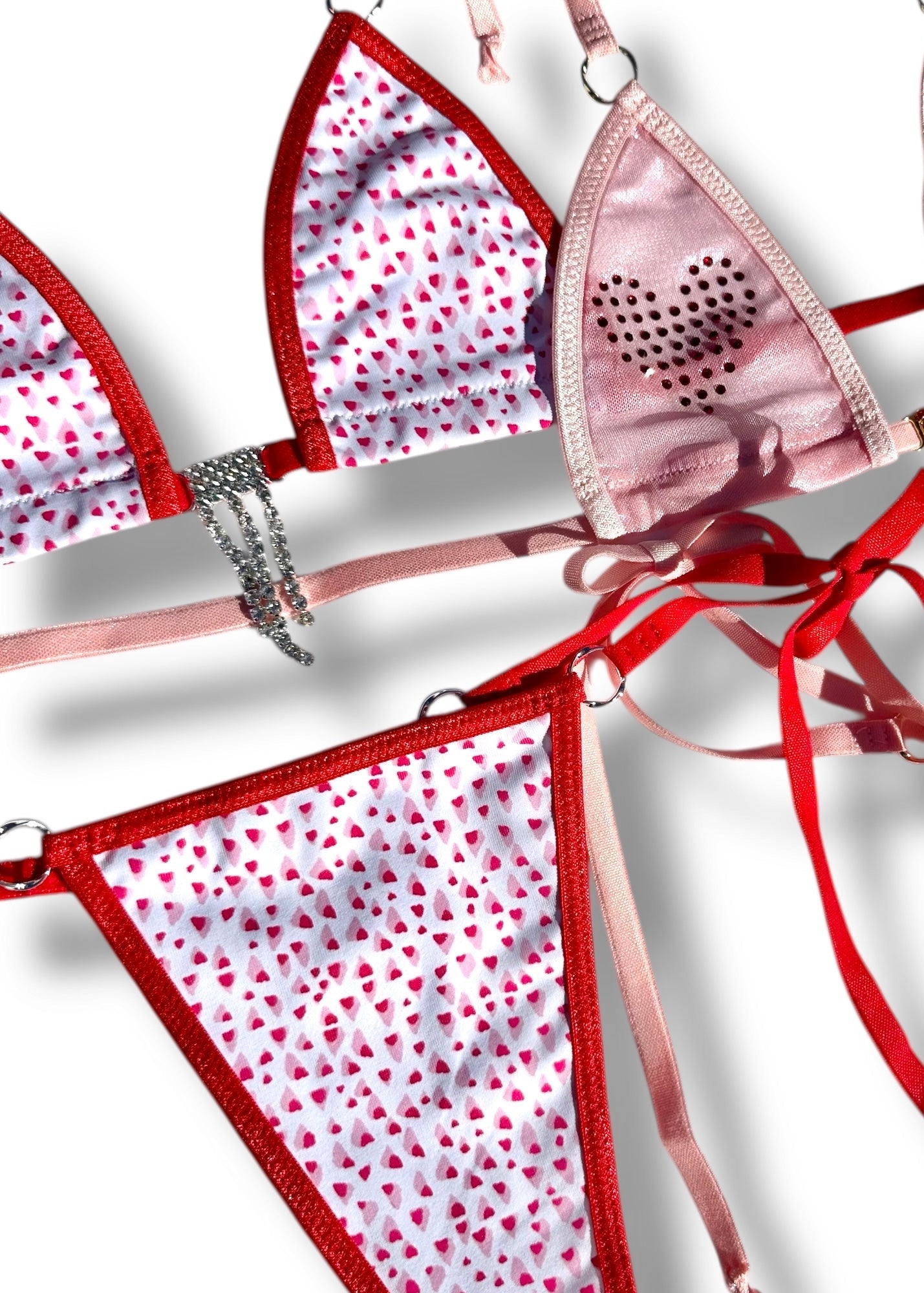 Pink and red bikini set with heart patterns on a white background