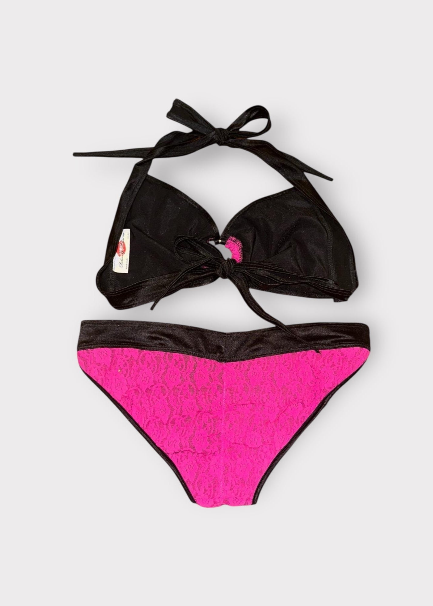 Black and pink bikini set on a light gray background