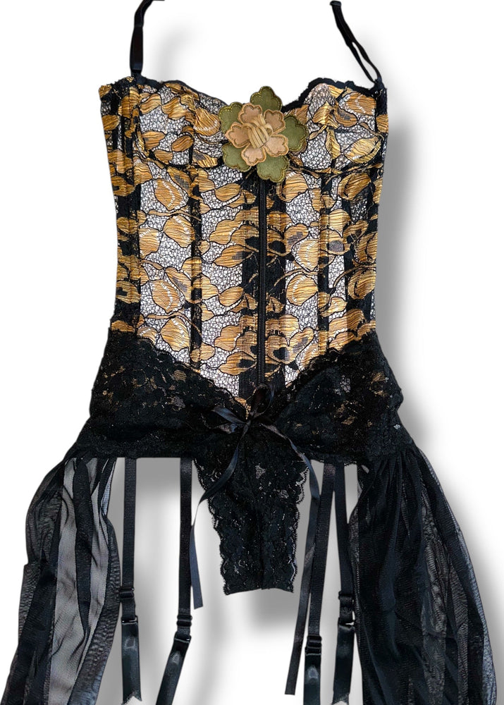 Black and gold floral dress hanging against a white background